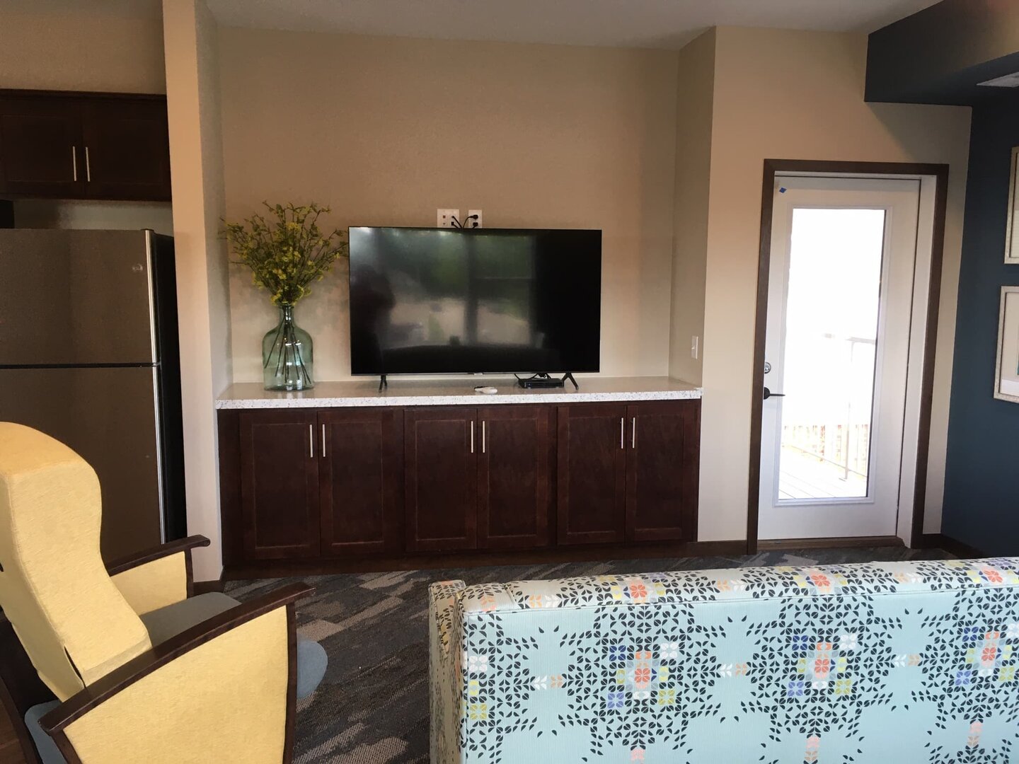 Living space with TV, wooden cabinets, and modern decor in a comfortable unit.