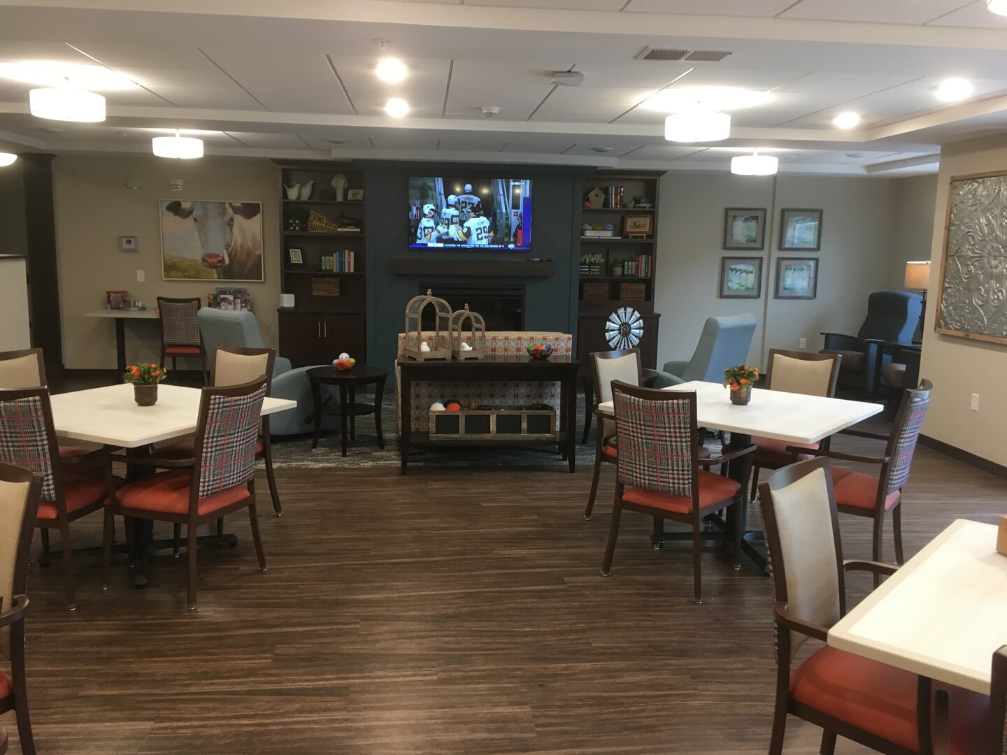 Cozy communal area with seating and TV in senior living community.