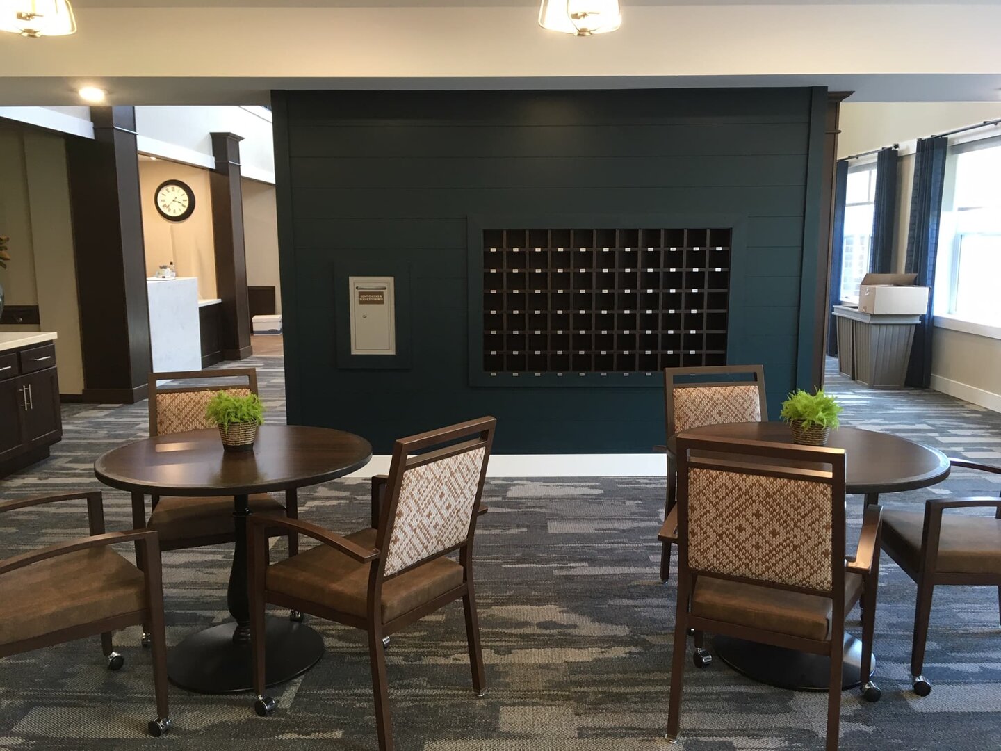 Lobby seating area with tables and chairs in senior living complex.