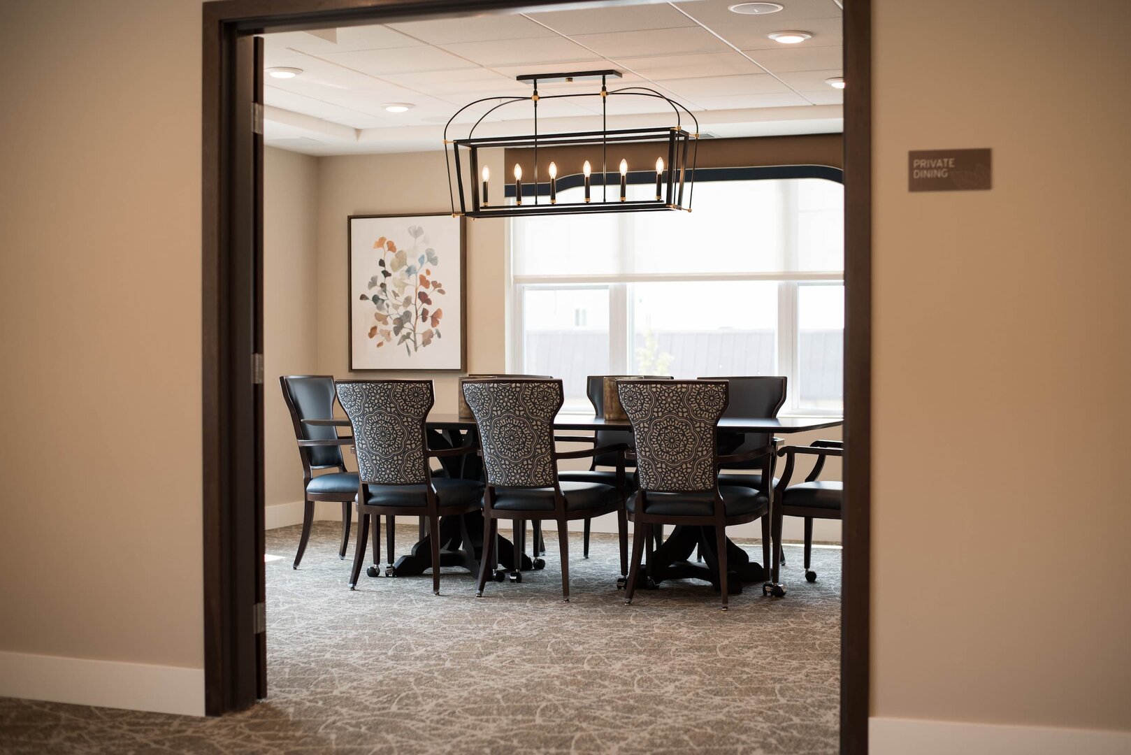 Private dining room with elegant chairs and a modern chandelier.