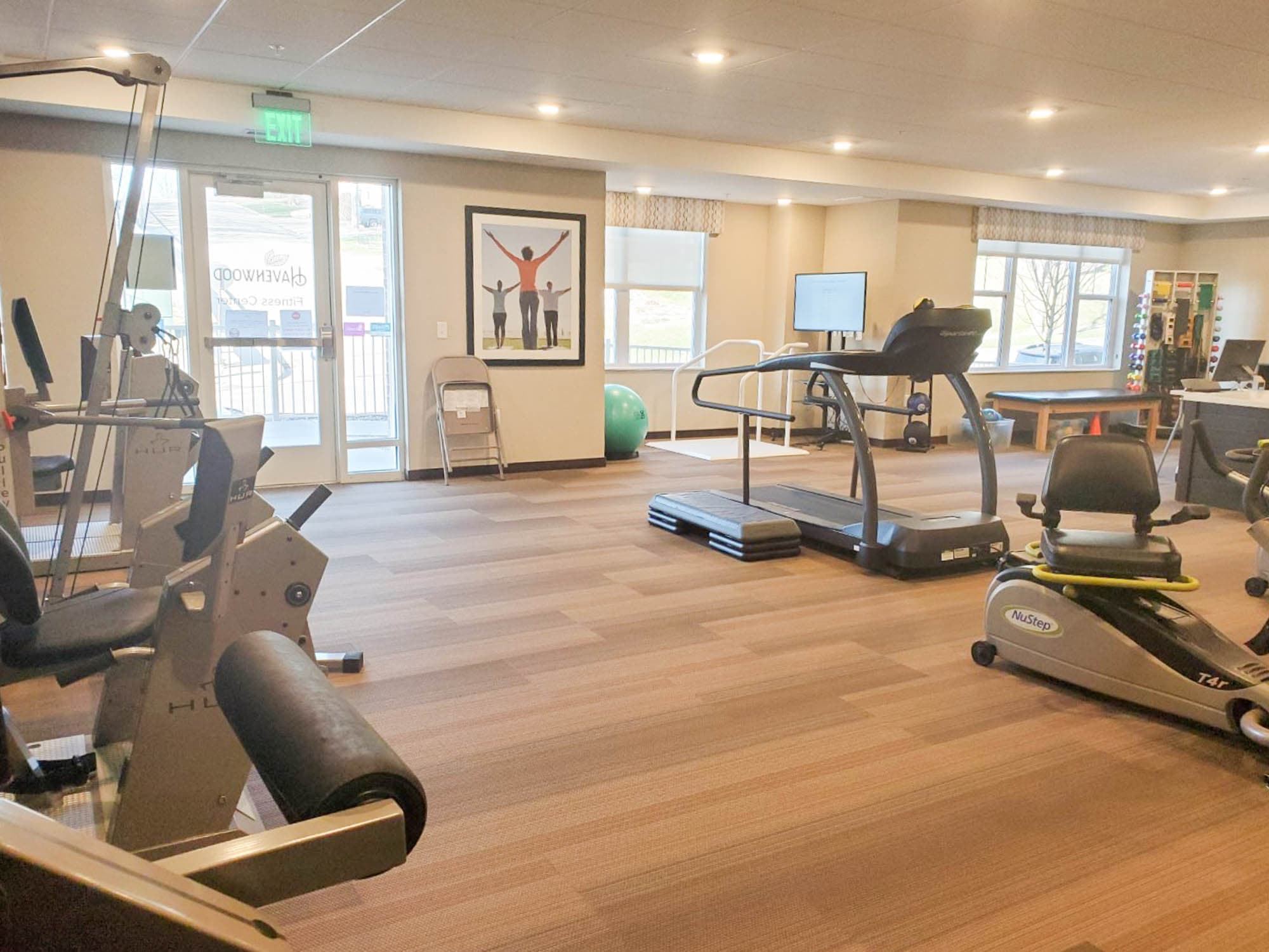 Modern fitness center with treadmills, exercise bikes, and bright natural light.