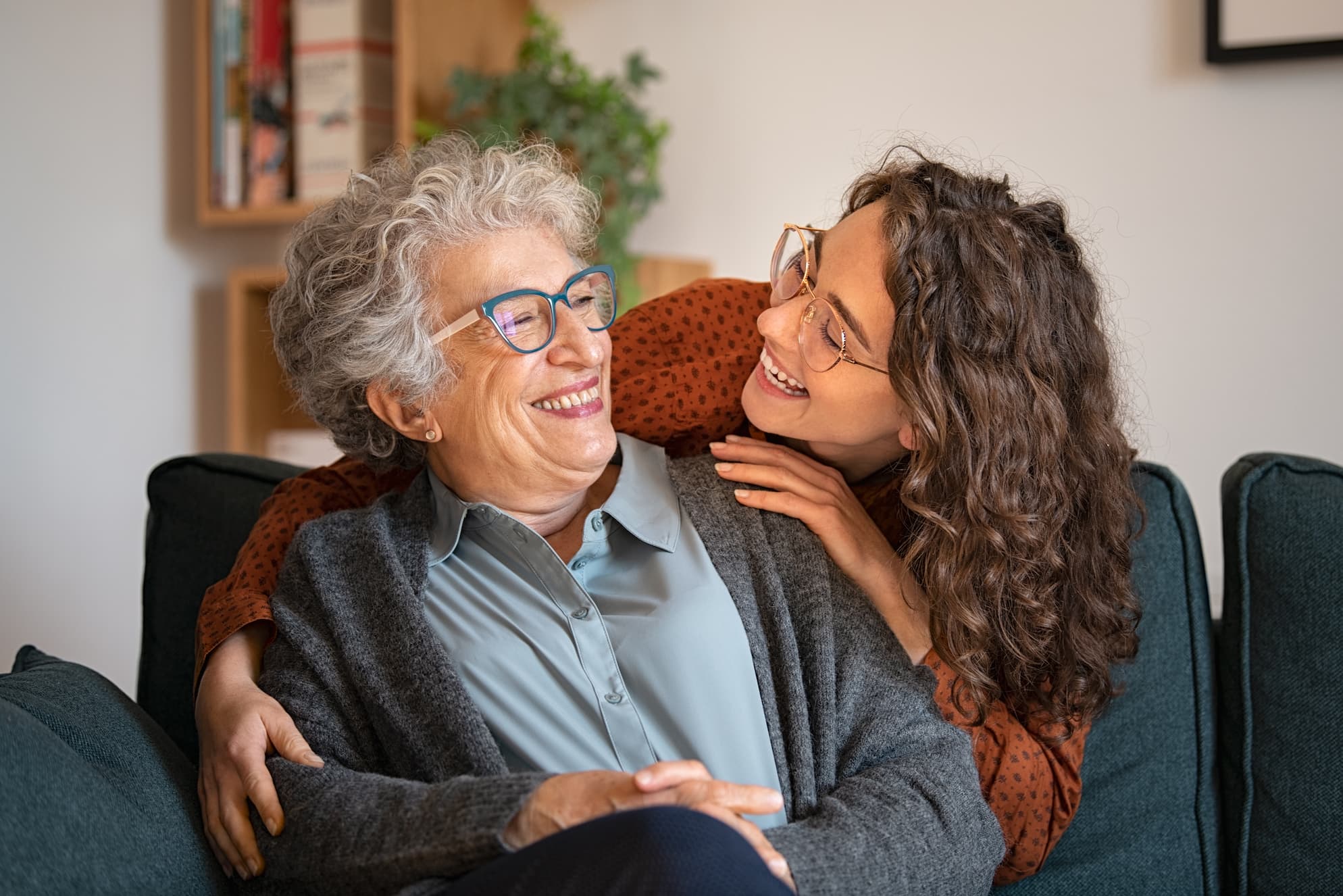 young-adult-embraces-senior-woman young caregiver embraces and smiles at senior woman
